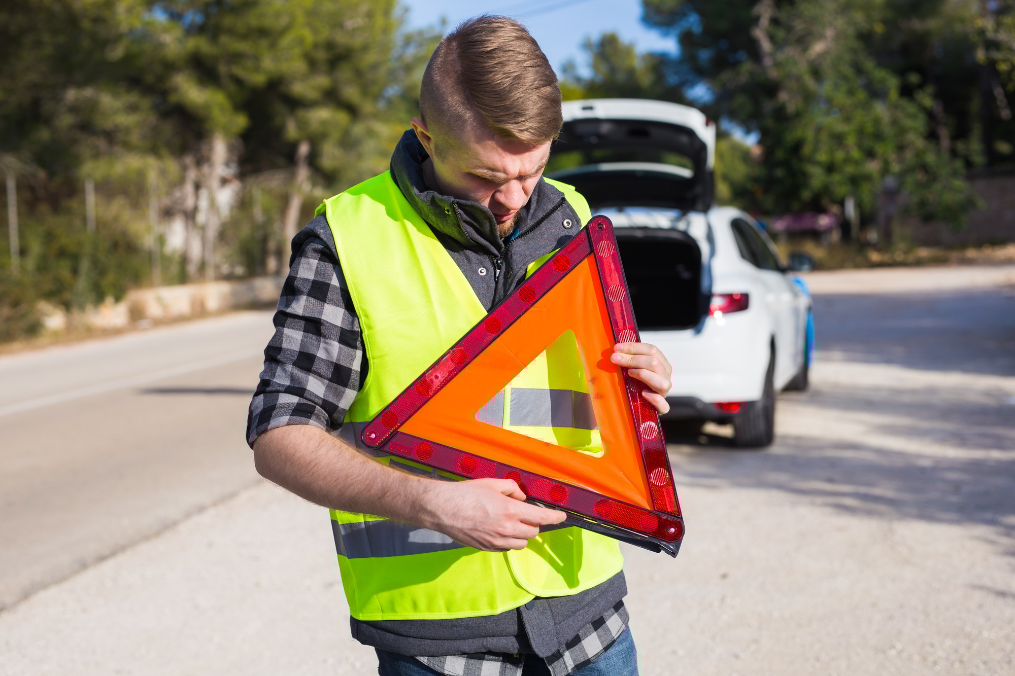 A man with a car gets an emergency sign