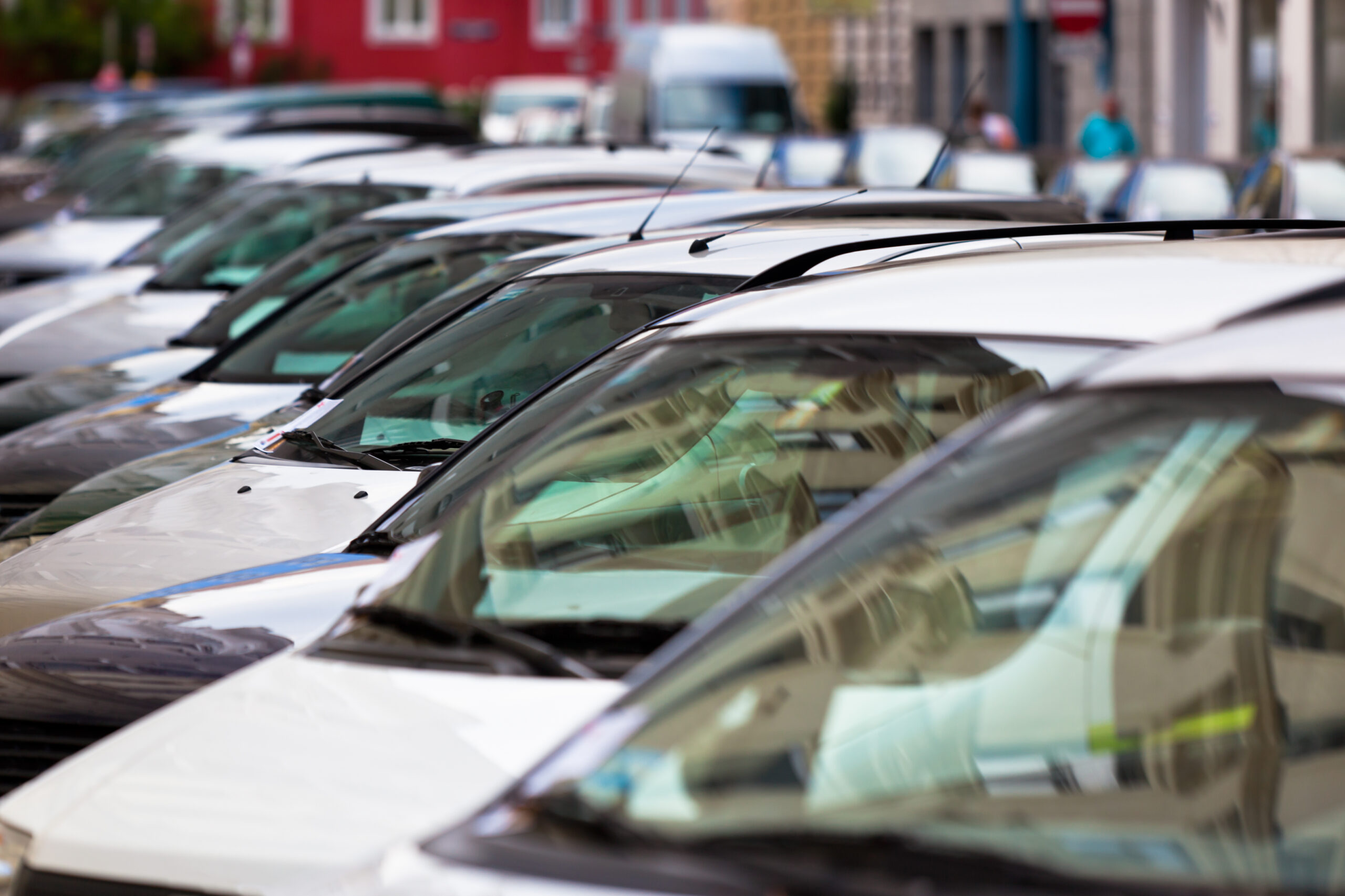Line of Cars on the city street. Bright houses as a background