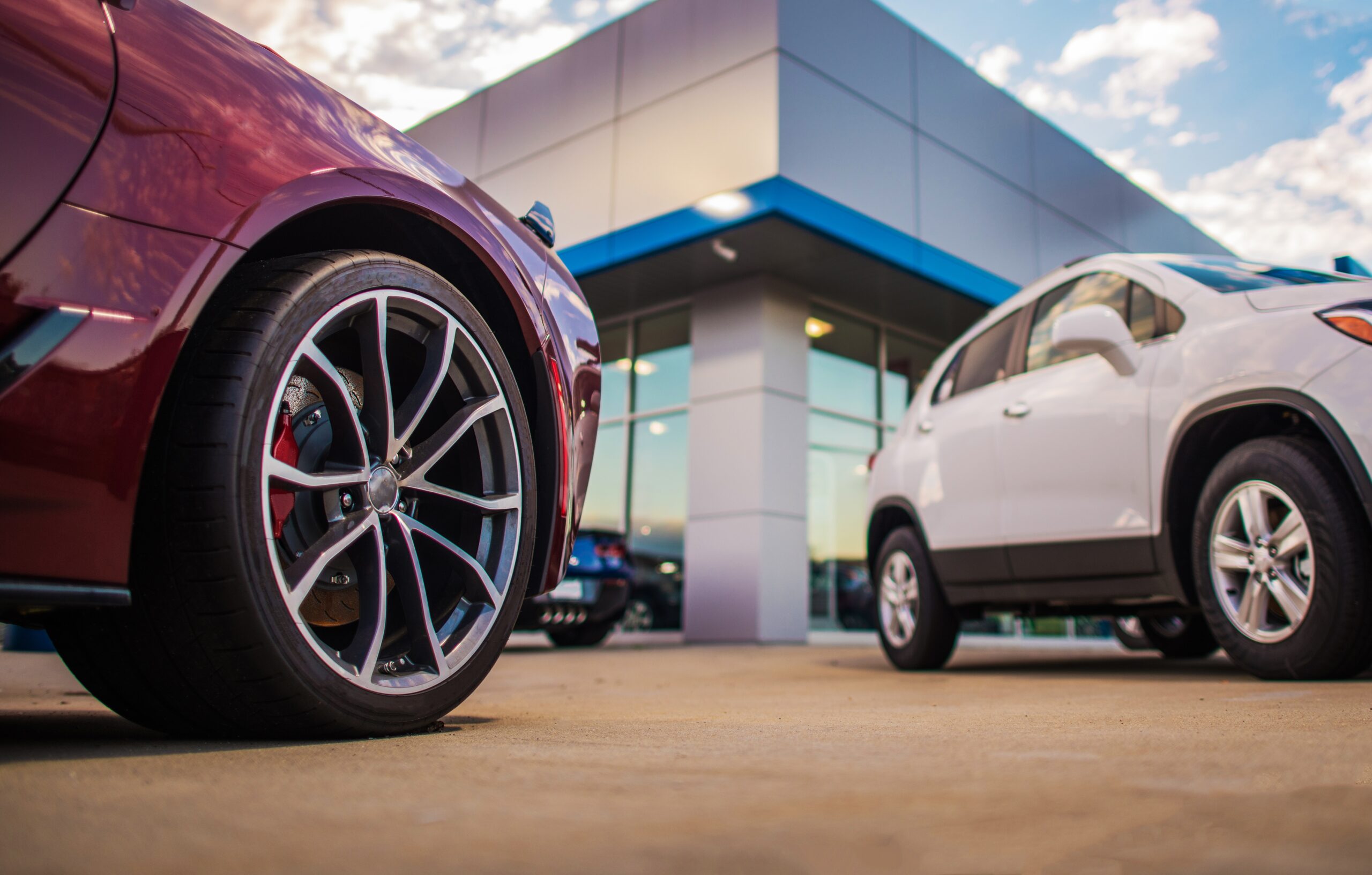 car dealership showroom with new and used vehicles outside