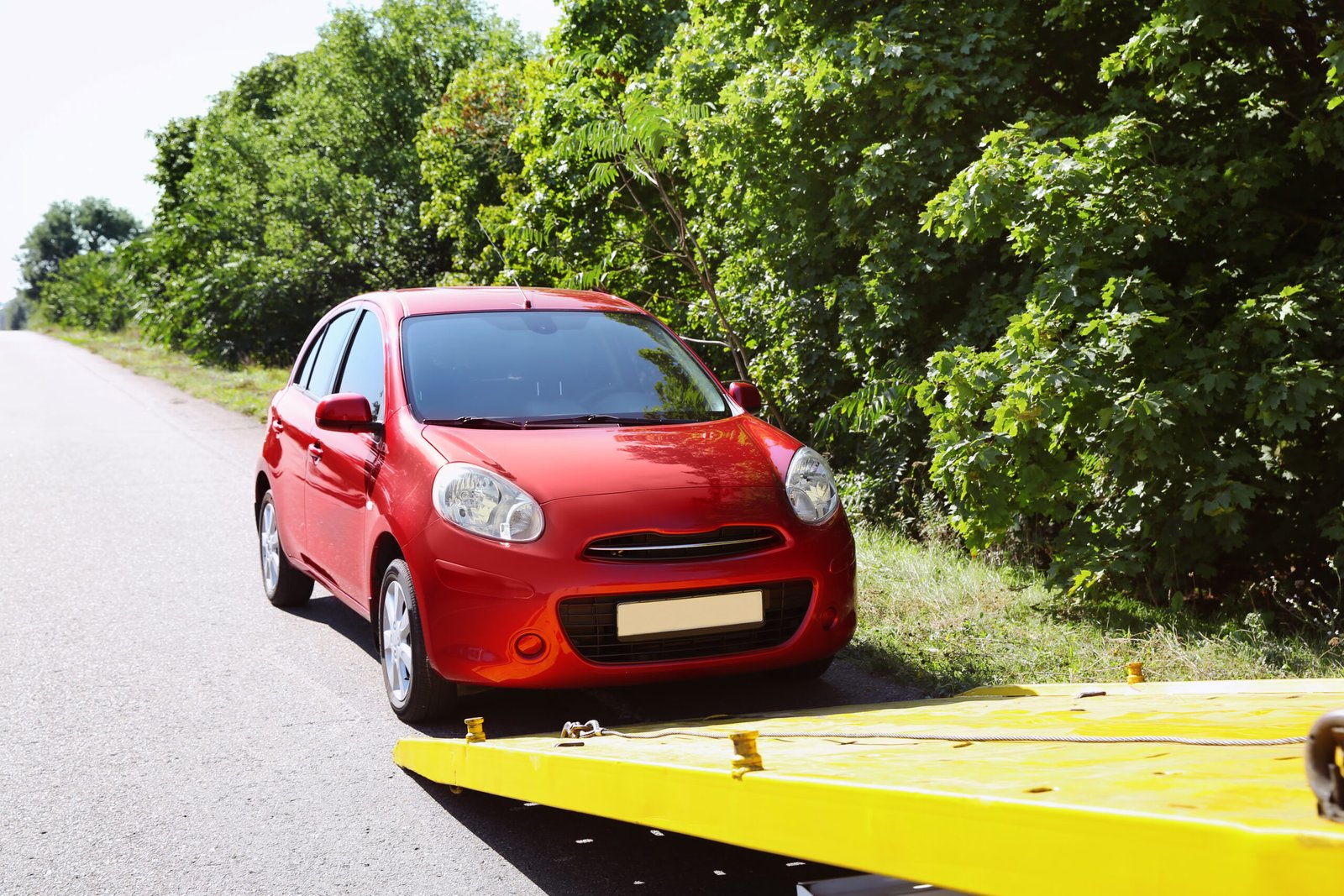 Car recovery Livingston – red broken-down car beside a recovery truck