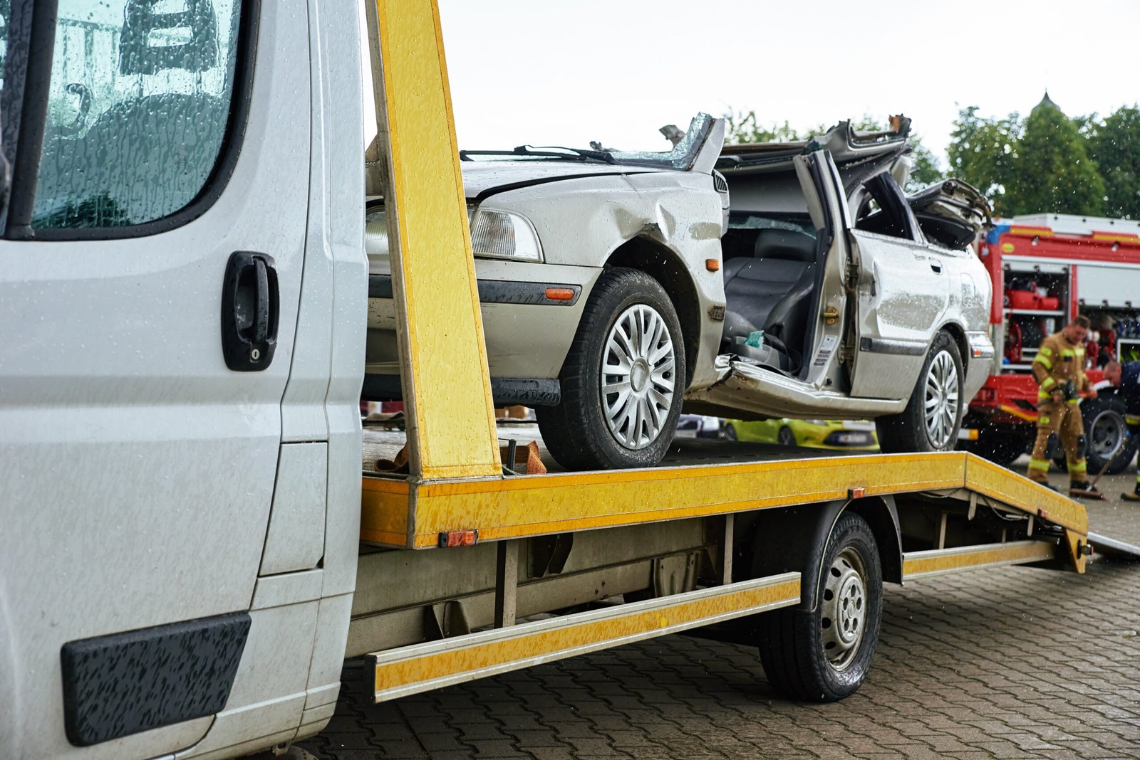 Damaged car being transported on a flatbed tow truck – car recovery West Lothian